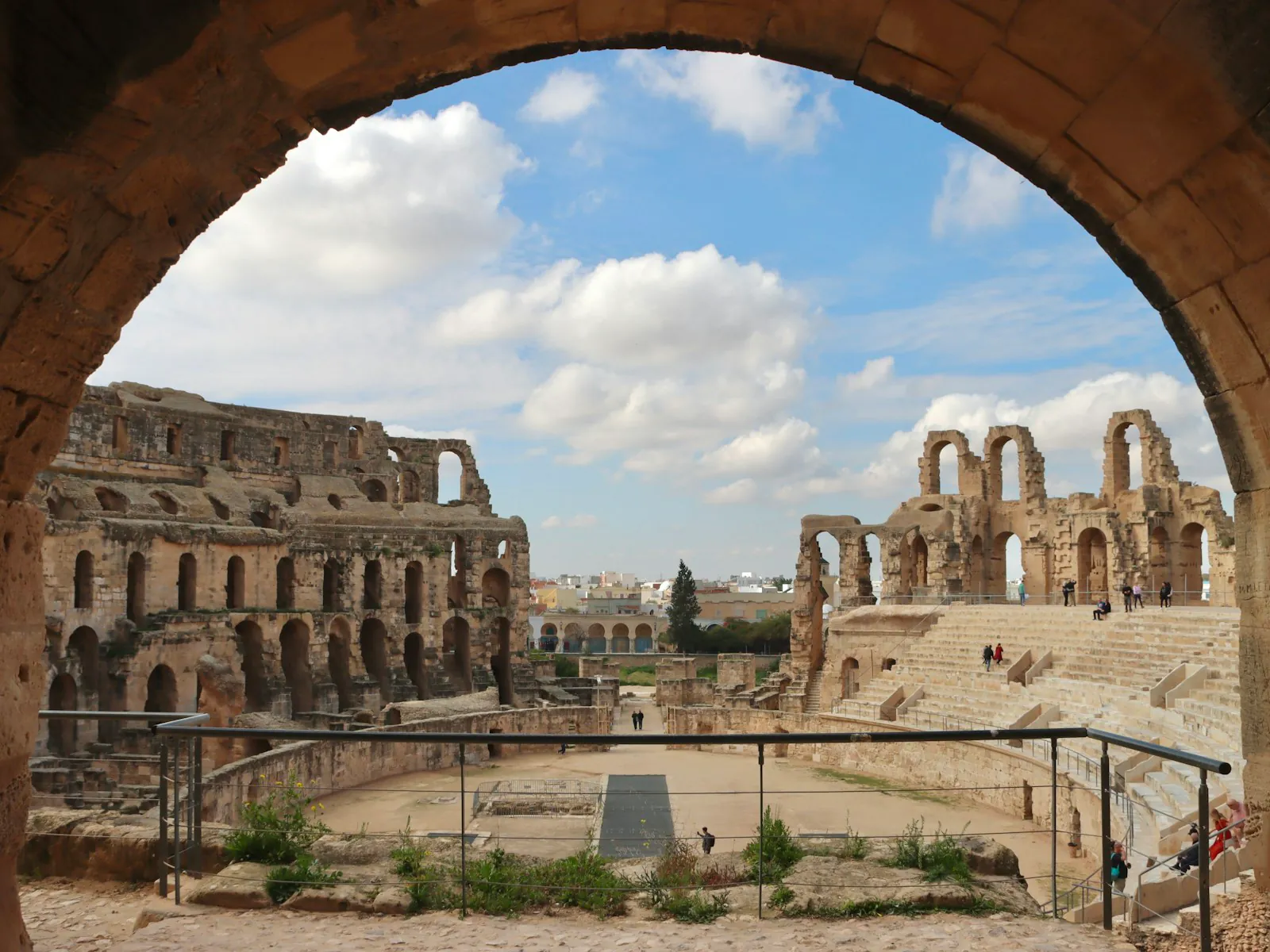 The amphitheatre of El Jem seen through a stone arch